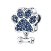 charm en argent représentant une patte sertie de zircons bleus avec un os suspendu