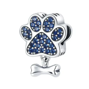charm en argent représentant une patte sertie de zircons bleus avec un os suspendu